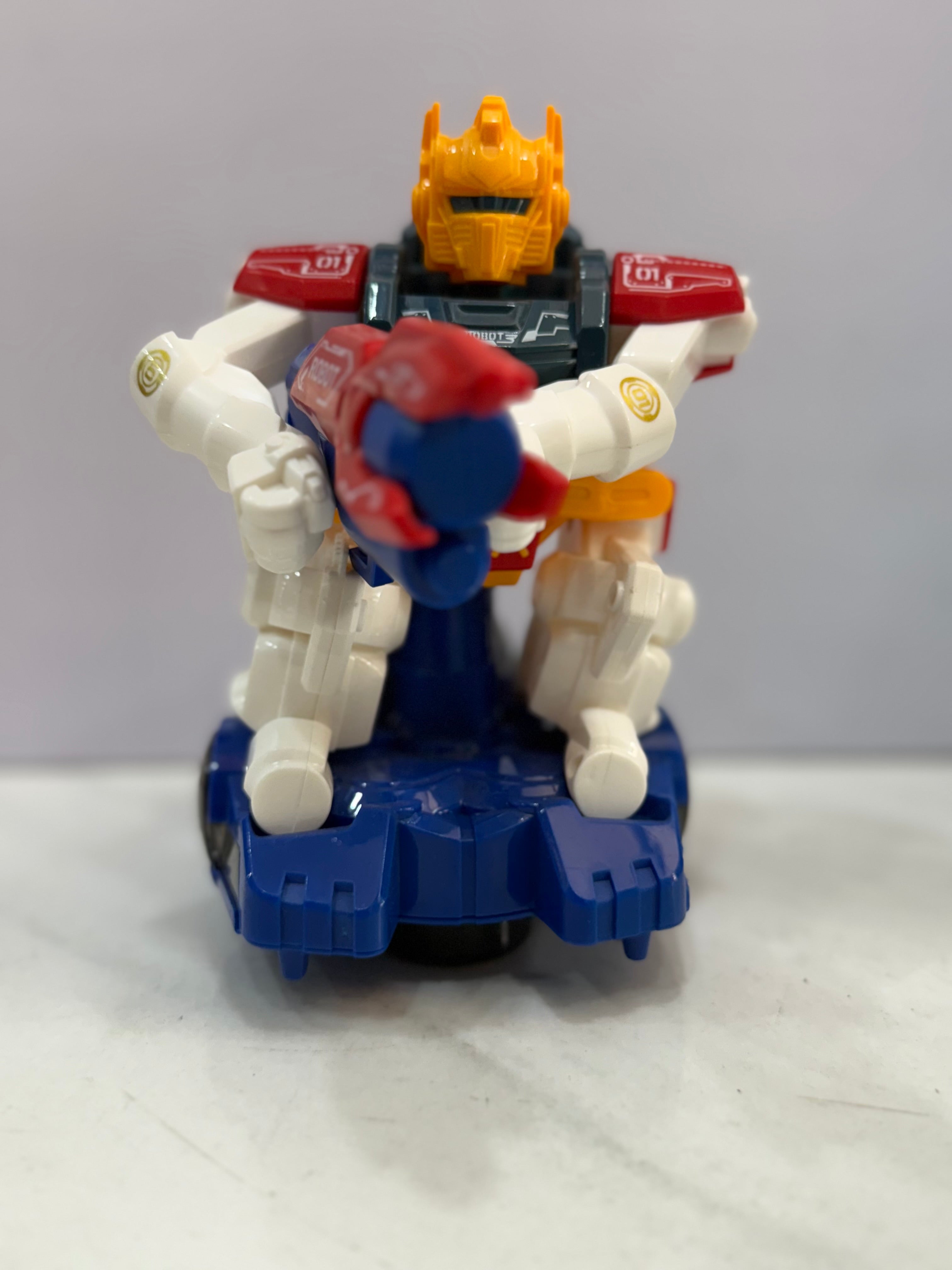 Toy figure with a yellow head and blue and red body on a white surface.